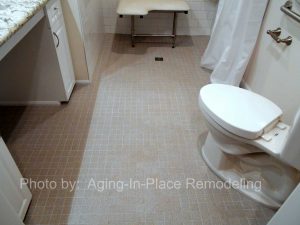 Wheelchair Accessible bathroom remodel with barrier free roll in shower, fold up shower seat, grab bars, hand held shower head, wheelchair accessible roll under sink