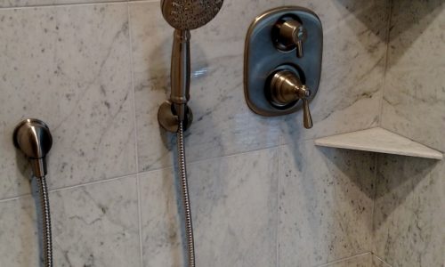 Custom Tile barrier free, roll-in shower with hand held shower head allows for wheelchair accessibility. Hand held shower head allows for easier use